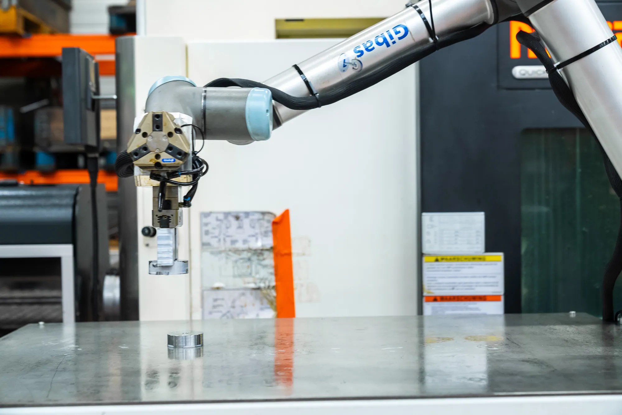Grijper van een collaboratieve robot boven een werkbank