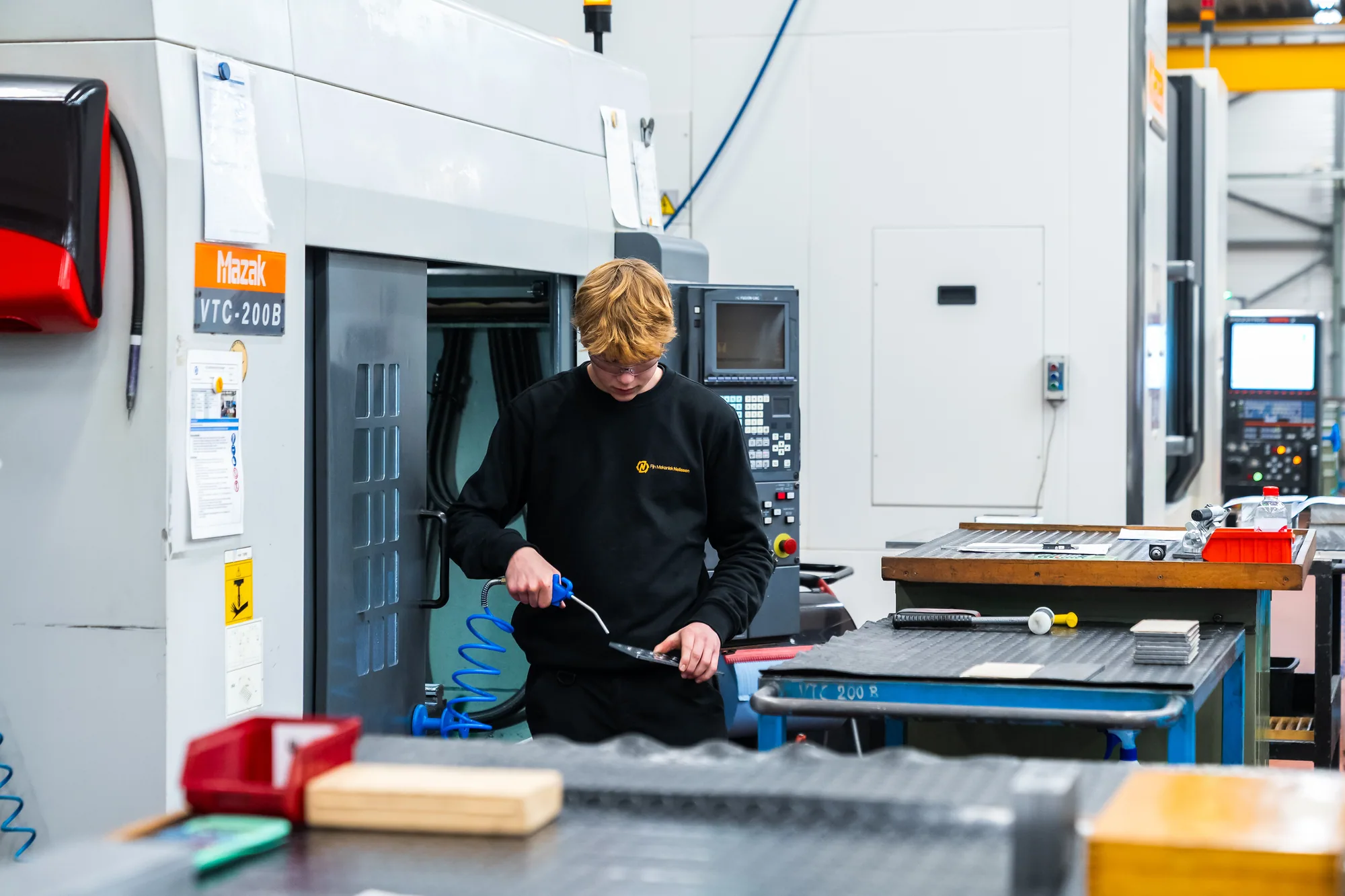Jonge operator aan het werk bij de machine