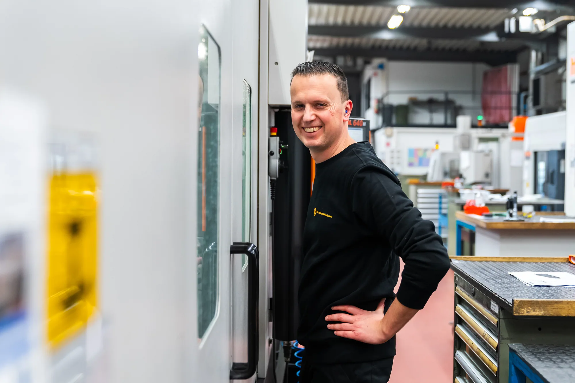 Operator naast zijn machine op de werkvloer
