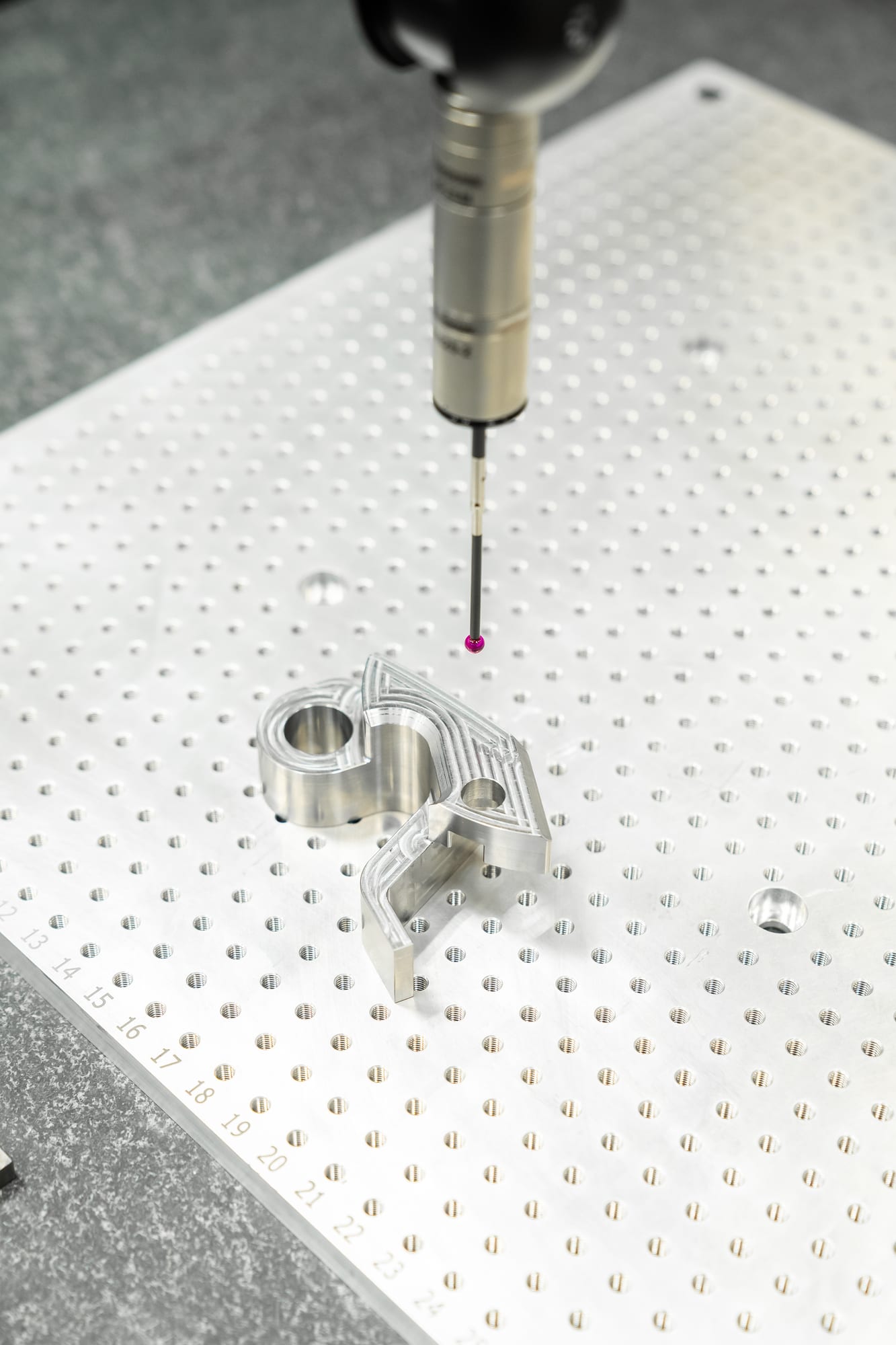 Verspaand aluminium onderdeel op de granieten meettafel, onder de tastpen van de coördinatenmeetmachine