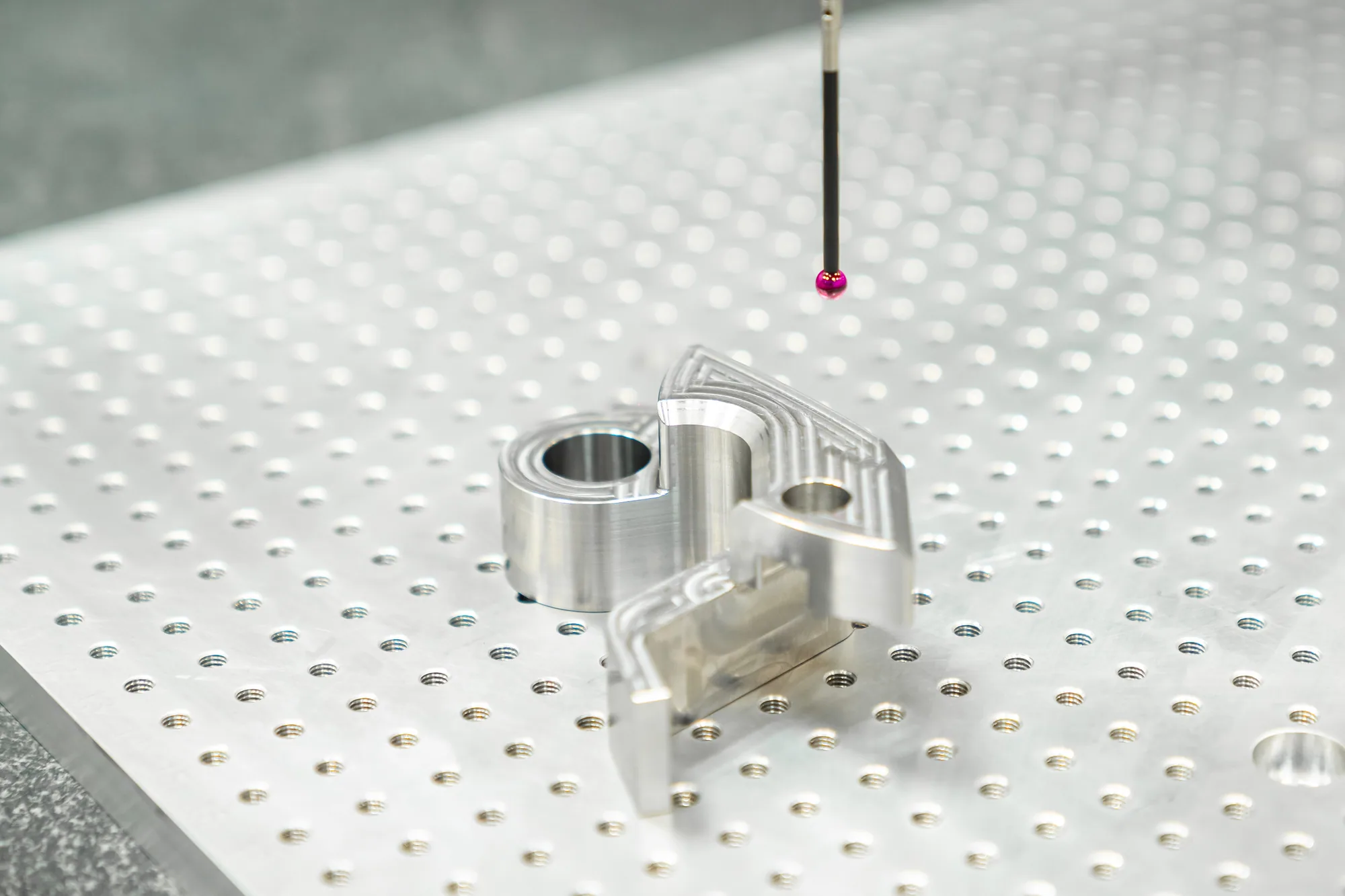 Tastpen van de meetmachine op een gefreesd aluminium onderdeel